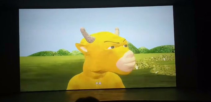 A projector displays an animated scene of a yellow bull character with horns standing in a green field, with the Chinese subtitle "牛来" (Niú Lái, meaning "Bull Comes") visible at the bottom. The poorly rendered 3D modeling and choppy animation in the image directly illustrate the user's criticism of the "abstract movie" they mention, which appears to be a crypto-themed promotional film that failed to meet expectations despite being hyped.
