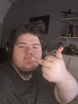 The image features a man with long hair wearing headphones, making a peace sign gesture with his fingers. He appears to be posing for a photo or video. The caption below the image reads "How the average Zebec Network hater looks like". This phrase is likely an inside joke or reference to the man's appearance in relation to the post about him.