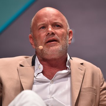 A bald, bearded man wearing a tan blazer over a white shirt speaks into a headset microphone during what appears to be a panel discussion, identified by the accompanying post as Galaxy CEO Mike Novogratz, who is warning about the consequences of the CLARITY Act failing to advance.