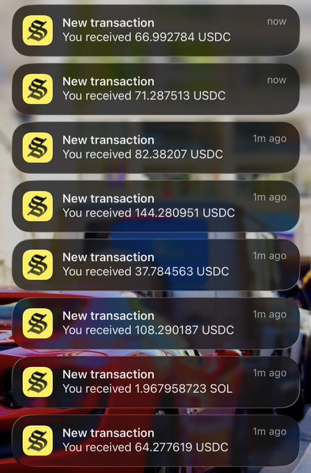 A smartphone screen displays a stack of push notifications showing a rapid succession of incoming crypto transactions, including USDC amounts like 66.992784, 71.287513, 82.38207, 144.280951, 37.784563, 108.290187, and 64.277619, along with 1.967958723 SOL, all received within the last minute—visually matching the post's joke about an "infinite money glitch" flooding the wallet.
