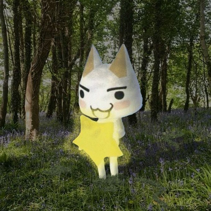 The image features a white stuffed animal cat with yellow ears, standing in a field of purple flowers. The cat appears to be holding a star above its head, giving the impression that it's a character from a video game or animated movie. The background consists of trees and bushes, creating an immersive environment for the cat character.