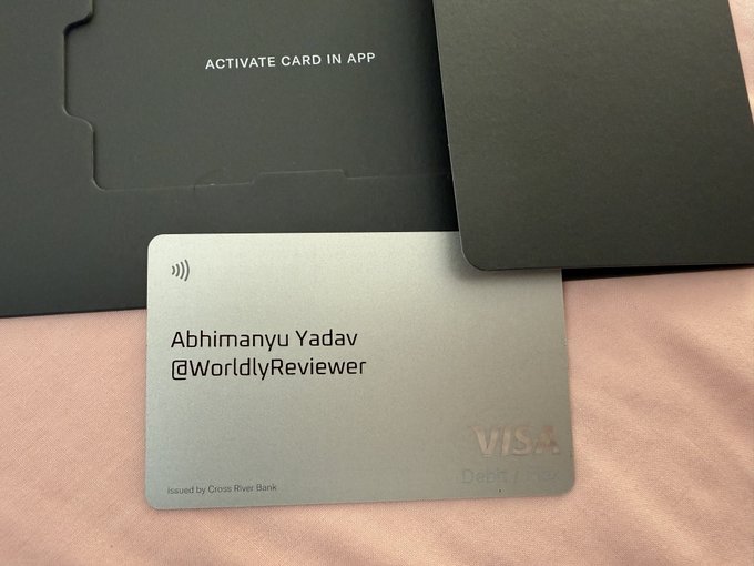 A silver Visa debit card issued by Cross River Bank, personalized with the name 'Abhimanyu Yadav' and '@WorldlyReviewer' handle.