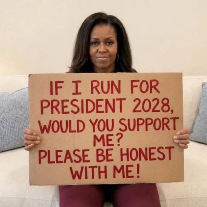 Michelle Obama sits on a couch holding a cardboard sign that reads in red marker: "IF I RUN FOR PRESIDENT 2028, WOULD YOU SUPPORT ME? PLEASE BE HONEST WITH ME!"