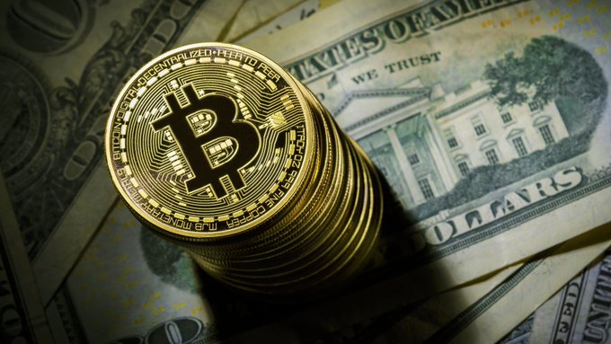 The image features a stack of gold Bitcoins placed on top of some US dollar bills. The Bitcoin is positioned at the center of the stack, while the dollar bills are arranged around it. The scene suggests that there might be an interest in cryptocurrency or digital assets, as they are often associated with decentralized systems and networks. This could potentially lead to a shift towards more ecosystem-based approaches rather than centralized platforms dominating the financial landscape.