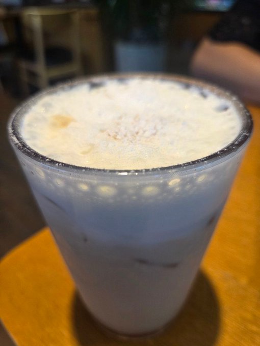A glass of pale, foamy milk tea is shown on a table. No text, numbers, or tickers are visible, but the post’s excited Bitcoin-rally reference suggests the drink is being enjoyed in a bullish crypto mood ahead of “TermMaxFi 텀맥스” listing.