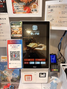 A self-service touchscreen kiosk at the Kingken (キング軒) ramen shop displays a payment screen accepting JPYC (Japanese Yen stablecoin), featuring a QR code for crypto transactions. The terminal is positioned beneath promotional signage advertising an "Irodori Lunch Set" for 1,000 yen, showcasing how the restaurant in Shiba Park has integrated digital yen payments into its ordering system.