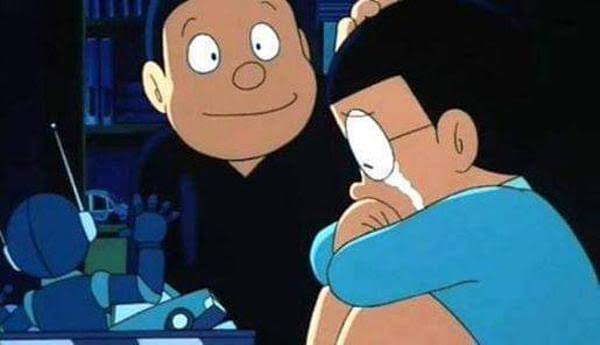 The image features a cartoon scene with two characters - one male and one female - sitting next to each other at a table. The male character has a sad expression on his face as he looks down, while the female character appears to be crying or wiping her eyes. In the background, there is another person who seems to be in distress. A robot toy can also be seen near them. The post includes text that reads "Don'c't cry, Nobita. So what if the yen's weak? Dad'S Trump coin' s down to 1/30th now, you know." This message suggests a sense of humor or lightheartedness about the current situation in the cartoon scene.