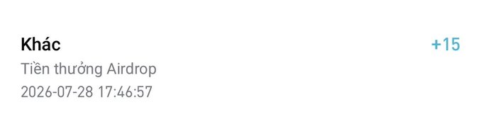 The image shows a transaction notification labeled "Khác" (Other) with a "+15" amount, dated 2026-07-28 17:46:57, described as "Tiền thưởng Airdrop" (Airdrop reward). It relates to the post by showing the small airdrop reward received, which complements the author's mention of incoming funds and pocket money for milk tea/lunch.