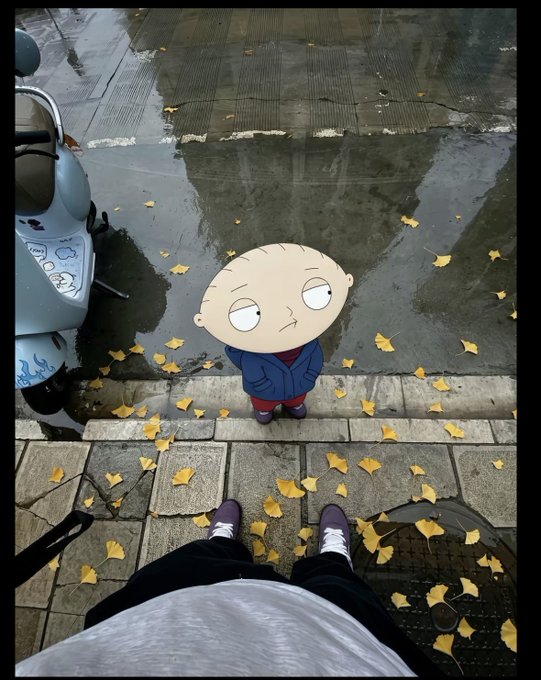 A first-person view looking down at a person's shoes on a sidewalk scattered with yellow leaves, with an animated Stewie Griffin character from Family Guy standing in front of them.