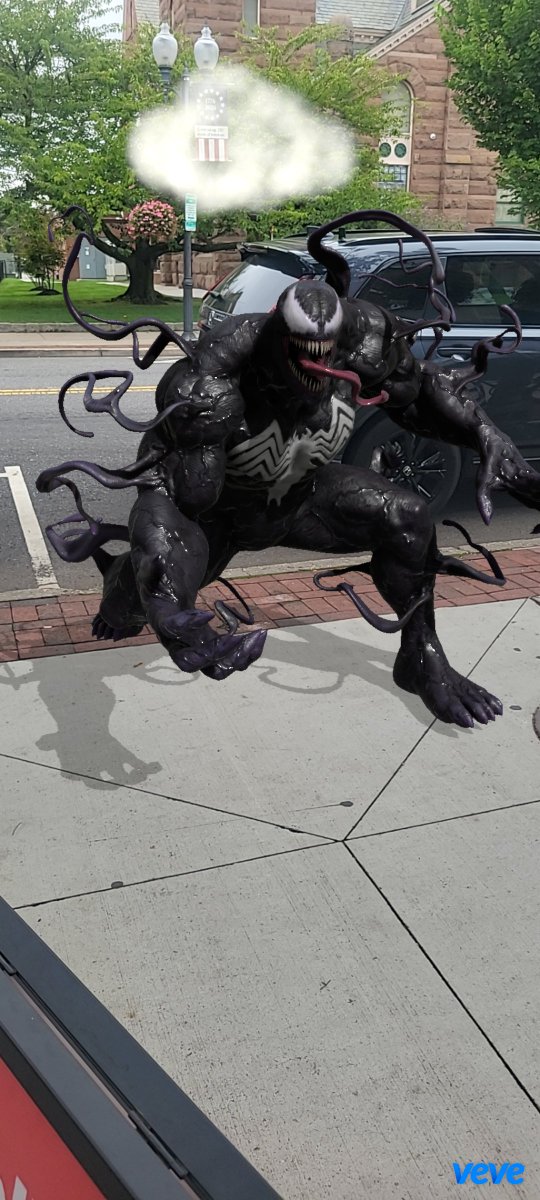 An AR/digital art rendering (branded with "veve" logo) showing the Marvel character Venom with symbiote tendrils in a crouched pose on a city street.