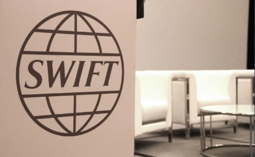 SWIFT logo plaque on a wall in an office lounge setting.