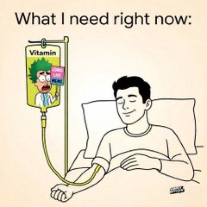 A meme showing a sick person in a hospital bed receiving an IV drip, with the IV bag labeled "Vitamin" featuring an image of Krusty the Clown from The Simpsons and a book titled "Love Live McGee" tucked into his pocket. The caption reads "What I need right now:" and the post references needing "vitamins" — humorously implying Krusty Clown's "Love Live McGee" book is the essential "vitamin" the poster craves.