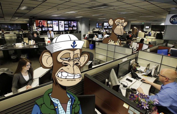 The image features a cartoon monkey sitting at a desk with a computer monitor, surrounded by cubicles filled with people working. The cartoon monkey appears to be wearing a sailor's hat and has a sad expression on its face. In the background, there are other cartoon monkeys as well.
