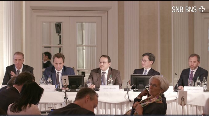 A panel of formally dressed individuals sits at a table labeled with number 6 during what appears to be a conference or discussion, with the "SNB BNS" logo visible in the corner. The image, though old, is referenced as showing "Brad and the gang," likely referring to Brad Garlinghouse and other notable figures associated with Ripple and the XRP cryptocurrency.