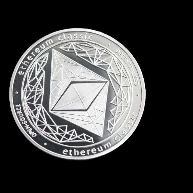 A silver 'ethereum classic' cryptocurrency coin displayed against a black background, showing the Ethereum diamond-shaped logo with 'ethereum classic' and 'OPEN-SOURCE DECENTRALIZED' inscribed around the edges.