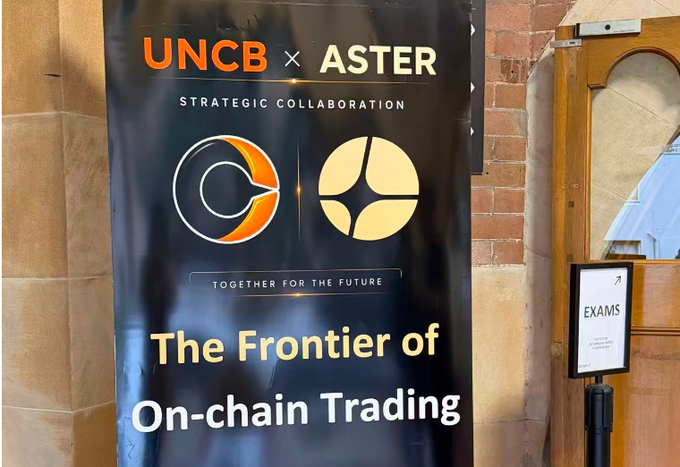 A black banner hanging outdoors near a brick wall and door announcing a 'UNCB x ASTER STRATEGIC COLLABORATION' with the tagline 'TOGETHER FOR THE FUTURE' and 'The Frontier of On-chain Trading'.