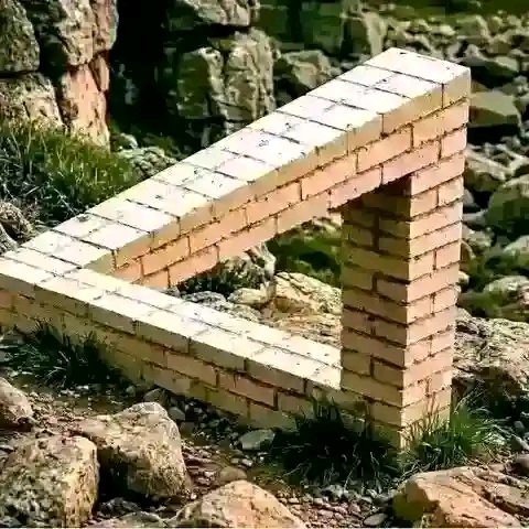 A real-world photograph of a Penrose triangle, an impossible object constructed from bricks, sitting on rocky terrain.
