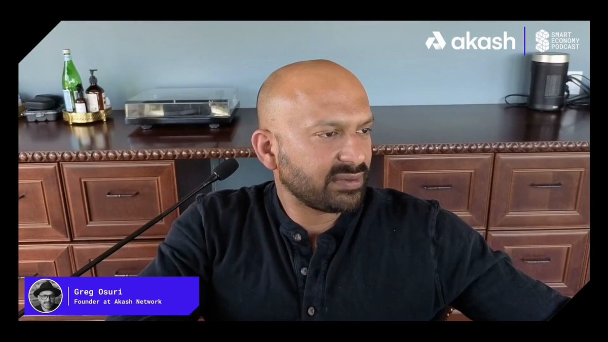 Greg Osuri, Founder of Akash Network, is shown on the Smart Economy Podcast, with on-screen graphics identifying him and the Akash Network branding, visually reinforcing the post about Akash's role in enabling consumers to participate in decentralized training swarms.