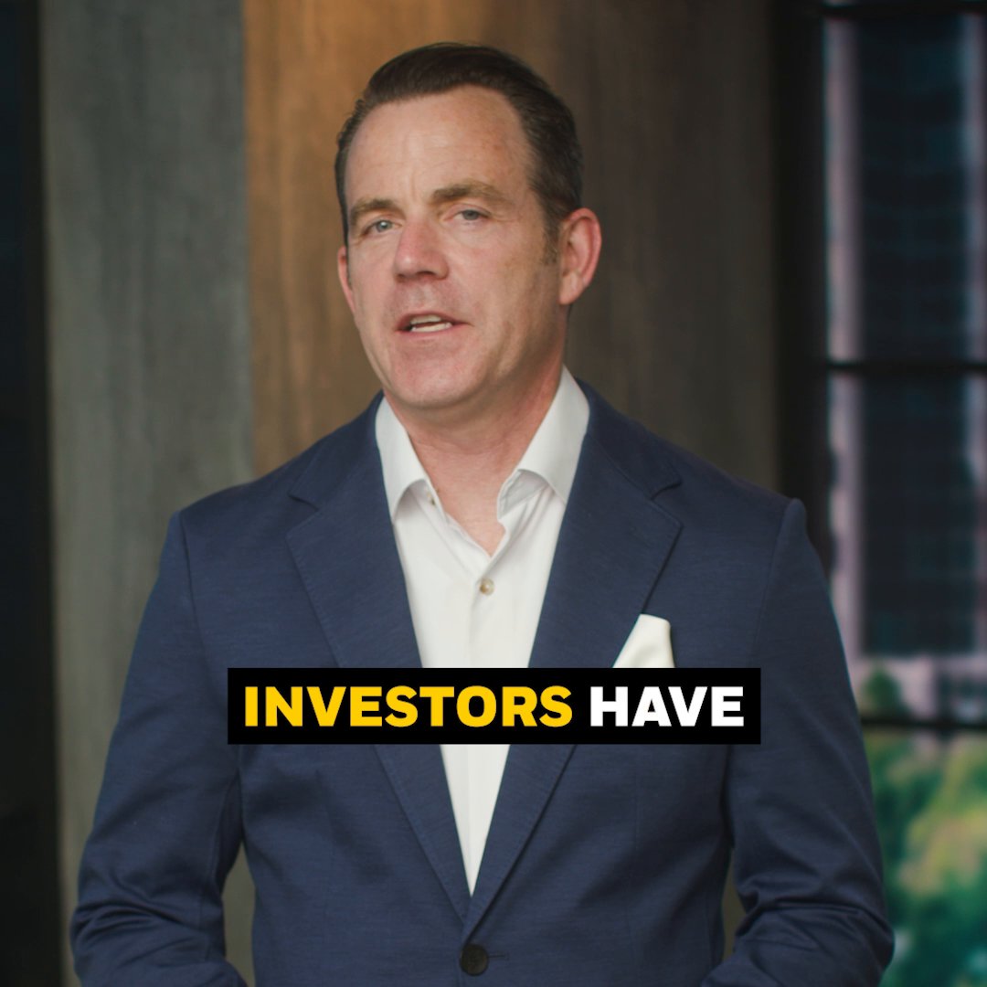 The image features a man dressed in a suit, standing against a wall with a window behind him. The text "Investors Have" is written above his head, while "World's largest asset manager BlackRock" is below his head. This suggests that the image might be related to an advertisement or promotional material for Bitcoin or cryptocurrency.