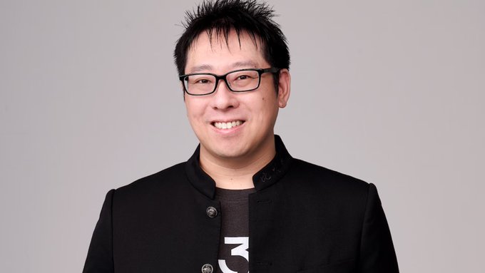 A man wearing black rectangular glasses and a dark jacket smiles at the camera, with what appears to be a partial number "3" visible on his shirt. The image accompanies news of Samson Mow's commentary on Bitcoin's role as a safe haven amid rising US 10-year Treasury yields.