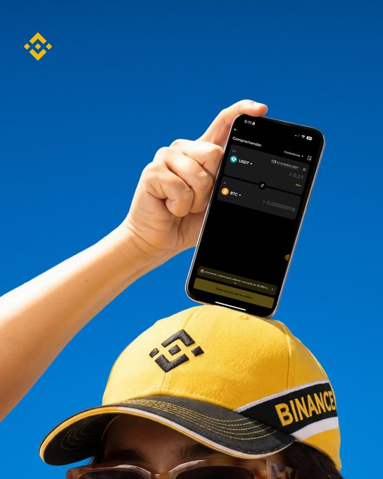 The image shows a person wearing a yellow baseball cap with "Binance" written on it, holding up their phone against a blue sky background. The caption of the image reads "USDT → BTC. Three taps on Convert and done." This suggests that the person is using an app to convert US dollars into Bitcoin or another cryptocurrency.