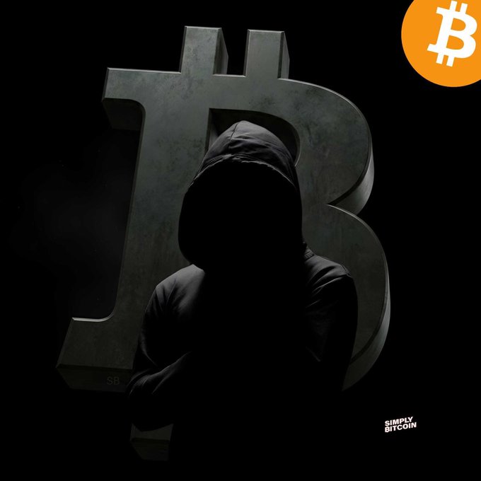 A hooded figure stands silhouetted against a large Bitcoin logo on a dark background, with a 'SIMPLY BITCOIN' watermark and an orange Bitcoin badge in the corner.