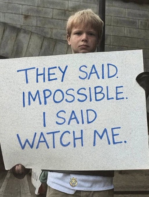 A motivational meme featuring a young blonde boy holding a handwritten sign that reads 'THEY SAID IMPOSSIBLE. I SAID WATCH ME.'