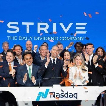 A celebratory scene at the Nasdaq with confetti falling as people applaud behind a podium; a screen displays 'STRIVE - THE DAILY DIVIDEND COMPANY' and the Nasdaq logo.