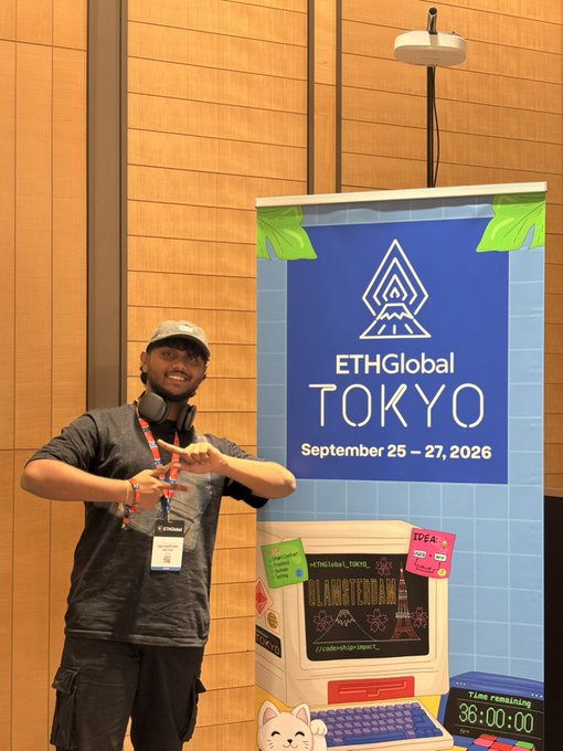 A man wearing a cap and headphones stands pointing at a banner for 'ETHGlobal TOKYO September 25-27, 2026' at what appears to be a tech event.