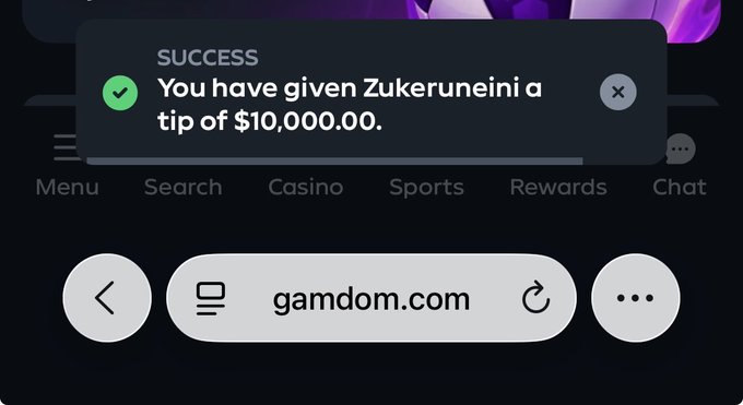 A mobile browser screenshot from gamdom.com displays a success notification confirming a $10,000.00 tip was given to user "Zukeruneini," aligning with the celebratory post about everyone being paid. The site menu options (Menu, Search, Casino, Sports, Rewards, Chat) are visible below the green-checkmarked success popup.