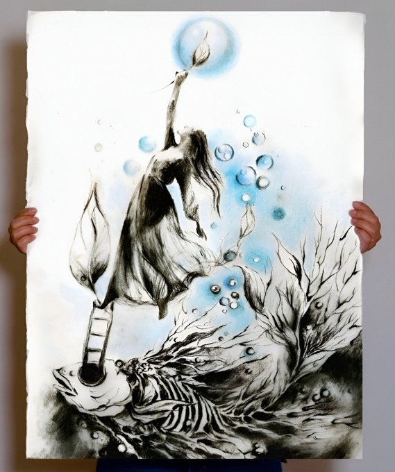 A person holds up a large mixed-media artwork featuring black ink drawings and blue watercolor washes depicting an ethereal figure reaching toward a glowing moon above an underwater scene with a sailboat ladder and skeletal fish bones. The dreamlike, surreal imagery complements the post's poetic caption about art as a fleeting, explosive moment, with the reference to objkt.com suggesting the piece is a digital collectible token on the Tezos blockchain.