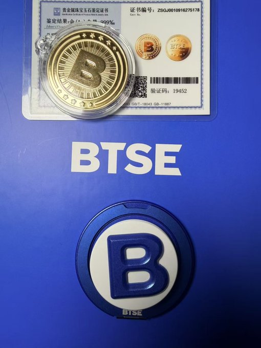 A BTSE Bitcoin commemorative gold coin in a clear case sits above a blue BTSE branded box, with a Bitcoin logo medallion below the 'BTSE' text.