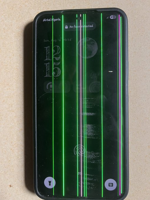 A smartphone with a severely cracked screen displays vertical green and pink lines, showing 'Airtel Nigeria', 'No face is detected', and the date 'Sun, Aug 16'.
