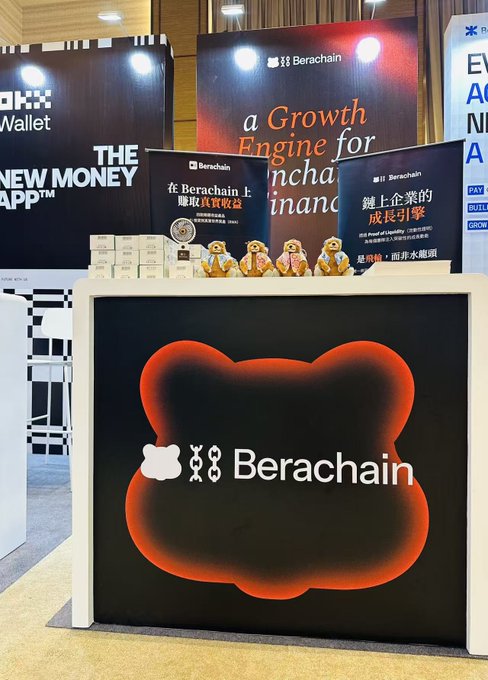 A booth display at a conference for Berachain, featuring a large bear-shaped sign with the project's name and logos, along with promotional materials in English and Chinese.