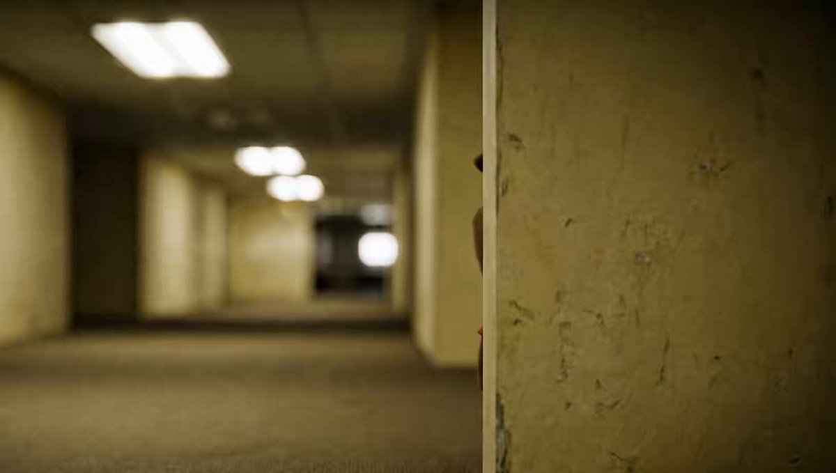 The image shows a hallway with a person standing near the end of the hallway, partially obscured by a door or wall. There are multiple doors along the length of the hallway, suggesting that this area may be part of an office building or another type of commercial space. The text "tomorrow is monday" in the caption indicates that it's Monday morning and the person might have just arrived at work or is about to leave for the day.