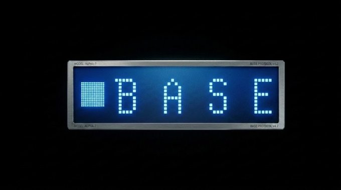 The image features a large blue sign with white letters that reads "Base" at the top of the frame. The sign is displayed against a black background, making it stand out prominently. The text appears to be in a digital format or an electronic display rather than traditional print.