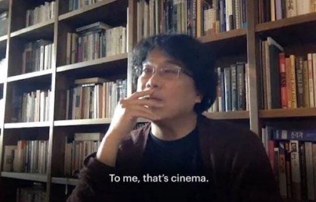 A man with glasses and a brown cardigan sits in front of a wall of bookshelves, holding his hand near his mouth, with the subtitle: 'To me, that's cinema.'