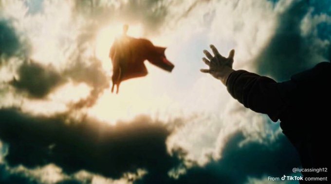 Cinematic TikTok screenshot showing a silhouette of a hand reaching toward a flying fox against a dramatic cloudy sky with sun flare.