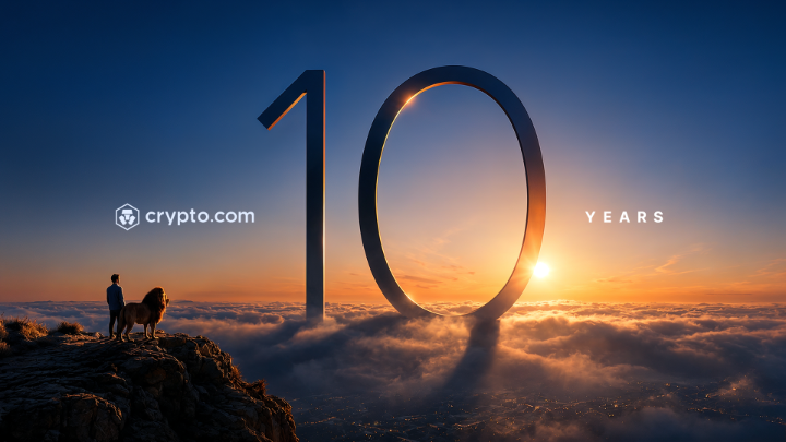 A silhouette of a man and lion stand atop a mountain peak above the clouds, with a giant "10 YEARS" alongside the "crypto.com" logo, celebrating the platform's 10-year anniversary milestone. The dramatic sunrise symbolizes the dawn of a new chapter in financial innovation, visually reinforcing the post's message about a decade of growth and a promising future ahead.