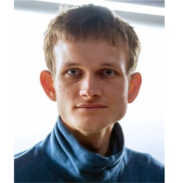 Headshot of a young man with short reddish-brown hair, wearing a blue turtleneck sweater, photographed against a bright background.