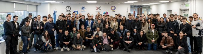 A large group of attendees poses together at the Midnight Connect Buenos Aires event, with logos from sponsors like Mid, Wolfram, Cardano Foundation, and Lace displayed on the wall behind them. The gathering reflects the expanding Midnight ecosystem, bringing together community members including Tom Humbert and Daniel Marquez from the Midnight Foundation for an evening of learning and networking.