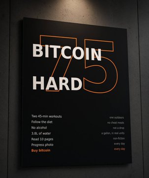 A framed poster on a dark wall reads 'BITCOIN HARD 75' in large orange-outlined letters, listing two 45-minute workouts including following the diet, drinking 3.8L of water, and reading 10 pages.
