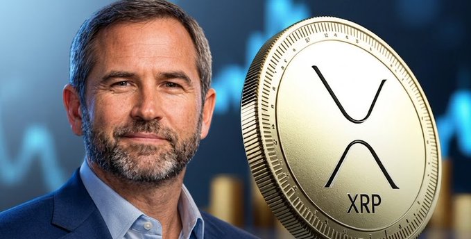 A bearded man in a suit stands beside a large gold XRP coin against a blue financial chart background.