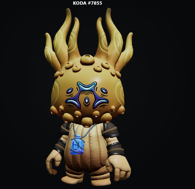 A digital render of a vinyl/designer toy figure labeled "KODA #7855," featuring a tan creature with flame-like protrusions, a blue rune-marked face, and a small blue vest with "GG" printed on it.