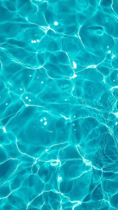 Clear turquoise swimming pool water displays light reflections and ripples across the surface.