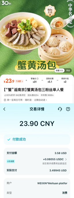 The image shows a cell phone screen displaying an advertisement for Chinese food, specifically a meal with meat and dumplings served in a bamboo steamer basket. The text on the screen indicates that the meal costs 2,959 CNY (3.49 US Dollars). The phone is placed on a table or countertop, suggesting it might be during a mealtime or while browsing for food options.