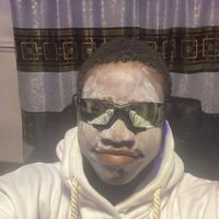 A person wearing dark sunglasses and a hoodie poses for a close-up selfie against a backdrop of curtains with decorative trim. The image aligns with the post's ironic humor about privacy and a $100k trading loss—using a sunglasses disguise as a tongue-in-cheek metaphor for trying (and failing) to stay anonymous after a devastating financial setback.