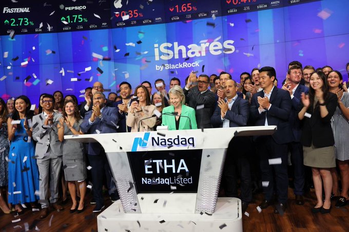 A celebratory scene at the Nasdaq stock exchange where a crowd applauds as confetti falls; the iShares by BlackRock logo appears on screen along with the Nasdaq podium displaying 'ETHA NasdaqListed'.
