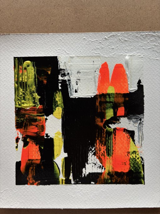 An abstract painting featuring bold brushstrokes in black, neon orange, yellow, and white on textured paper, displayed against a brown background.