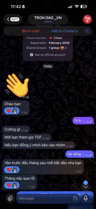 The image shows a phone screen displaying a conversation between two people. The text of their messages includes words like "block", "user", "contacts", and "@TronDao_VIE chính thức kết nạp thêm trùm content X @1Kaiweb3 Xin mãi mới có slot này ương job web 3 chúc anh em đoàn kết nhé". The conversation appears to be about a shared account or contact information.